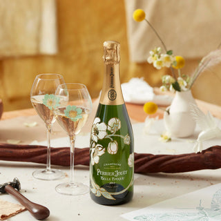 Perrier-Jouet Belle Epoque champagne bottle with two glasses on a decorative table setting.