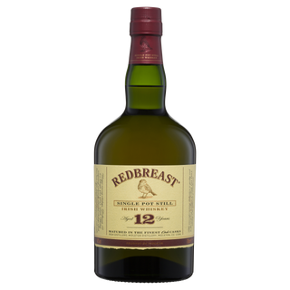 A bottle of Redbreast 12 Year Old Single Pot Still Irish Whiskey, with a cream label, maroon cap, and gold accents featuring a bird illustration, offers notes of spicy fruitcake and sherry sweetness.