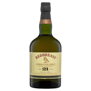 A bottle of Redbreast 21 Year Old Single Pot Still Irish Whiskey features a green glass body, cream label with red text, dark cap, and gold seal, and is celebrated for its dried fruit and roasted nut notes.