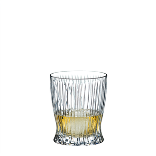 Clear glass with a textured base filled with a yellowish liquid on a white background