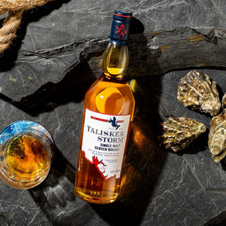 A bottle of Talisker Storm Single Malt Scotch Whisky next to a glass of whisky.
