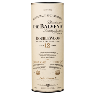 A cream-colored cylindrical tube for The Balvenie DoubleWood 12 Year Old Single Malt Scotch Whisky, with black and gold text highlighting its age, sherry and oak casks, distillery info, and signature honeyed notes.