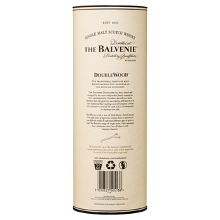 A cylindrical cream-colored container holds The Balvenie DoubleWood 12 Year Old Single Malt Scotch Whisky, with black text highlighting its honey and oak notes, brand history, and a barcode at the bottom.