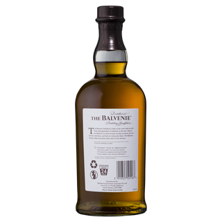 The Balvenie Stories The Sweet Toast of American Oak 12 Year Old Single Malt Scotch Whisky seen from the back, showcasing its white label with information, recycling symbols, and barcode. The amber liquid suggests notes of oak spice and vanilla. Set on a plain white background.