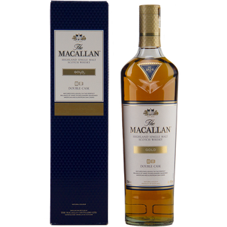 A bottle of The Macallan Double Cask Gold Single Malt Scotch Whisky with a gold cap and label stands beside its blue and gold box, displaying the light amber hue of the whisky inside.