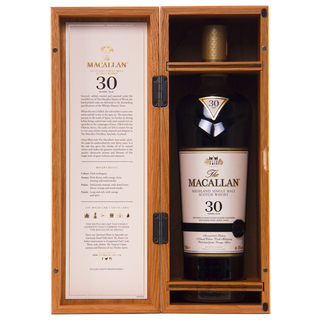 The Macallan 30-year-old whisky bottle in a wooden box with an open lid showing text.