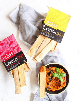 Lavosh crackers with Urban Pantry packaging on a white surface with a bowl of dip.