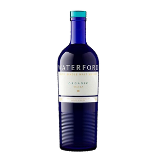 A blue glass bottle of Waterford Organic Gaia: Edition 2.1 Single Malt Whisky with a white and gold label, hinting at orchard fruits and sweet malt, is displayed against a plain white background.