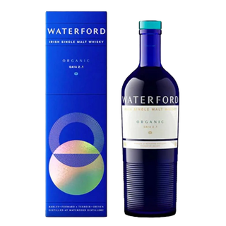 A blue bottle of Waterford Organic Gaia: Edition 2.1 Single Malt Whisky stands beside its matching blue box, decorated with colorful geometric circles and white text, hinting at orchard fruit and sweet malt flavors inside.