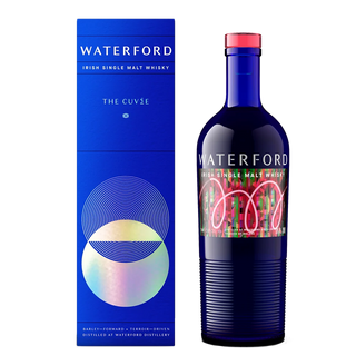 A blue bottle of Waterford The Cuvée Single Malt Whisky stands by its matching blue box with geometric designs, labeled WATERFORD and THE CUVÉE—celebrating rich malt flavors and hints of orchard fruits.