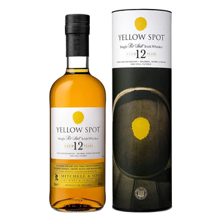 A bottle of Yellow Spot 12 Year Old Single Pot Still Irish Whiskey stands beside its cylinder packaging, both adorned with a yellow spot logo and black-and-white labels, suggesting tropical fruit and peach notes in each sip.
