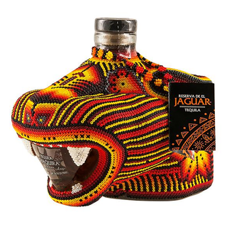 Chaquira Anejo Tequila 750ml comes in a bottle adorned with colorful beads forming a jaguar’s head, detailed in yellow, red, orange, and black patterns. The branded tag reads Reserva de El Jaguar Tequila with notes of caramelized agave.