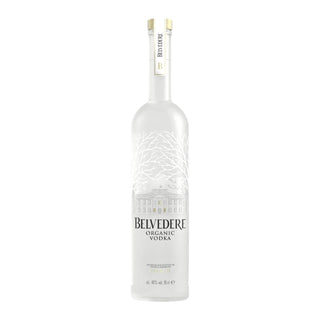 A tall frosted glass bottle of Belvedere Vodka 700ml with a white and gold cap, featuring an illustration of trees and a building. The label reads Belvedere Vodka, renowned for its balanced flavor and smooth texture.