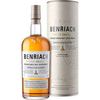 A bottle of Benriach Smoke Season Single Malt Scotch Whisky stands beside its cylinder packaging, both displaying the brand name and details with gold, black, and white accents, evoking smoked vanilla and rich oak spice notes.