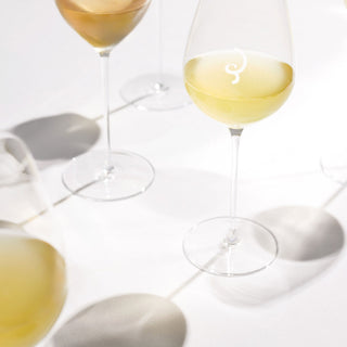 The Billecart-Salmon Le Blanc de Blancs Grand Cru NV + 2 Glasses Gift Set is displayed on a white surface, highlighting the elegant glasses and evoking a minimal scene with citrus and chalky mineral hints.