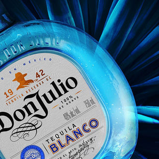 Close-up of a Don Julio Blanco Tequila 700ml bottle label, highlighting branding and text against a dynamic blue abstract background—reflecting the essence and smooth finish of this agave tequila.