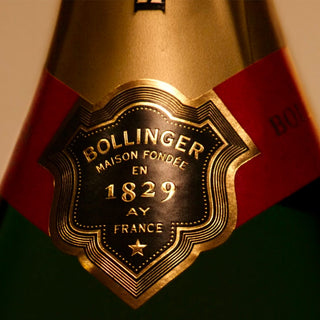 Close-up of a gold and black label on a Bollinger Special Cuvée Brut NV 3L bottle, showing “Bollinger Maison Fondée en 1829 Ay France,” with decorative borders and a red neck label, hinting at its refined spice and creamy palate.
