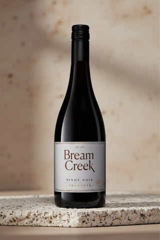 Bream Creek Pinot Noir wine bottle on a stone surface with a neutral background