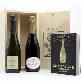 The Revolution Grower Champagne Gift Box features two bottles of mineral-driven grower Champagne in a wooden box, paired with Robert Walters' book "Champagne: A Secret History," known for its black cover with gold accents and a champagne bottle illustration.