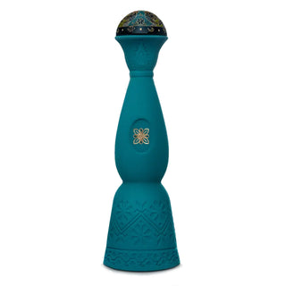 The tall, teal blue bottle of Clase Azul Mezcal Guerrero features an ornate, dome-shaped cap with embossed floral patterns and gold detailing—an elegant vessel that hints at the honeyed sweetness inside.