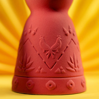 A close-up of the Clase Azul Mezcal San Luis Potosi 750ml bottle, featuring red ceramic with embossed roosters and agave plants against a vibrant yellow background, evokes a smoky, herbal ambiance.