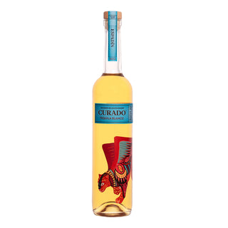A tall, clear bottle of Curado Tequila Blanco - Infusión de Agave Espadin 700ml features a blue label and cap plus a colorful winged jaguar illustration, delivering smooth tequila with vibrant citrus and agave notes.