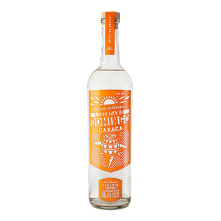 A clear glass bottle of Domingo Mezcal Especial Espadin Oaxaca 700ml features an orange and white label with bold text and an agave design. The mezcal inside is clear with smoky notes and hints of roasted agave.