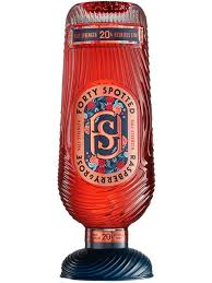 Red glass bottle with blue and white label on a black background