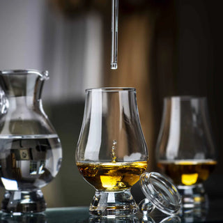 Glass of whiskey with a decanter and another glass in the background