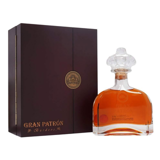 A bottle of Gran Patron Burdeos Añejo Tequila 750ml, displaying amber liquid beside its elegant dark brown gift box with gold accents, offers sweet agave and toasted oak notes from Bordeaux wine barrel aging.