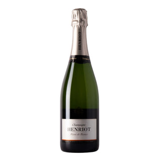 A bottle of Henriot Blanc de Blancs NV, featuring green glass, a white label with black and gold text, and a silver foil neck—celebrated for its fine bubbles and vibrant fruit flavors.