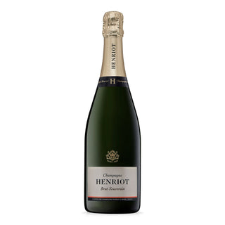 A bottle of Henriot Brut Souverain NV champagne, with a gold foil top and dark green glass, features a white label accented in gold and black and is celebrated for its fine bubbles and bright fruit flavors.