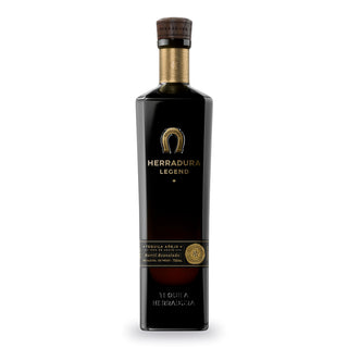 Herradura Legend Anejo Tequila 750ml features a tall, dark glass bottle with a gold horseshoe logo, wood cap, and gold text label. Inside is añejo tequila offering rich toasted oak and vanilla notes in every pour.