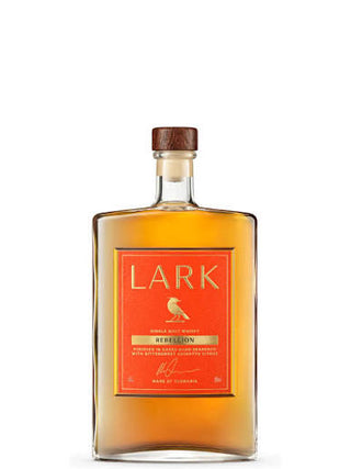 A bottle of Lark Recessional single malt Scotch whisky, featuring a clear glass bottle filled with amber liquid, a prominent orange label with gold lettering, and a dark brown wooden stopper, set against a plain white background.