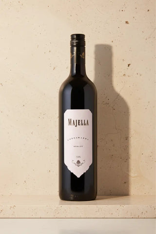 Red wine bottle with 'Majella' label on a beige surface
