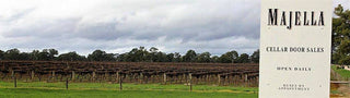 Wine cellar door sign with vineyard in the background