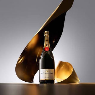 Moet & Chandon champagne bottle with artistic gold and black sculpture on a gray background