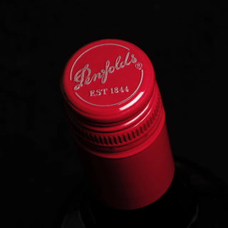 Red bottle cap with 'Penfolds' branding on a black background