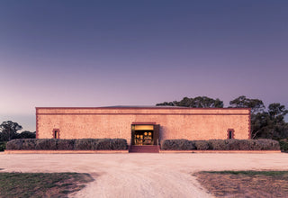 Rectangular brick building with a dark entrance at dusk