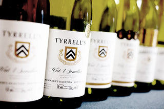 Row of Tyrrell's wine bottles with labels on a blue surface