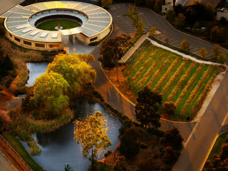 Aerial view of a circular building with greenery and water features